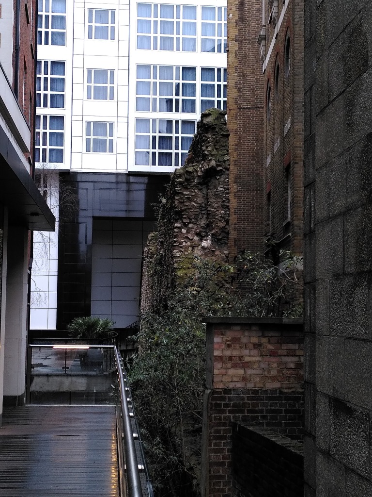A Roman wall between modern buildings in London.